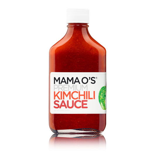 A bottle of Mama Os Premium Kimchili from Mama Os Premium Kimchi—a vibrant vegan hot sauce with a white cap, bold black and red label, partial green lime illustration, and bright red sauce—ideal for adventurous food lovers.