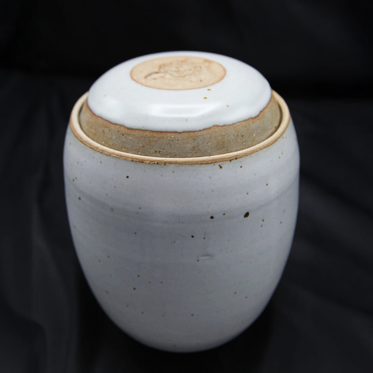 The Custom handmade Mama Os Homemade Kimchi Kit by Mama Os Premium Kimchi features a speckled light gray ceramic jar with lid and natural clay accents, ideal for making kimchi, shown against a black background.